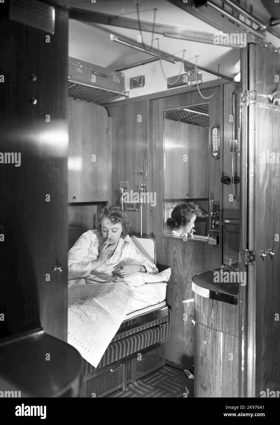 AB02C, voiture de classe 1st. La femme lit un journal et fume une cigarette. Banque D'Images