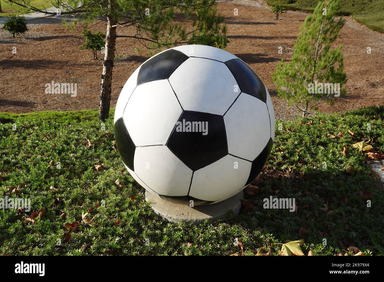 Ballon de football en béton pour l'aménagement paysager du parc sportif public. Banque D'Images