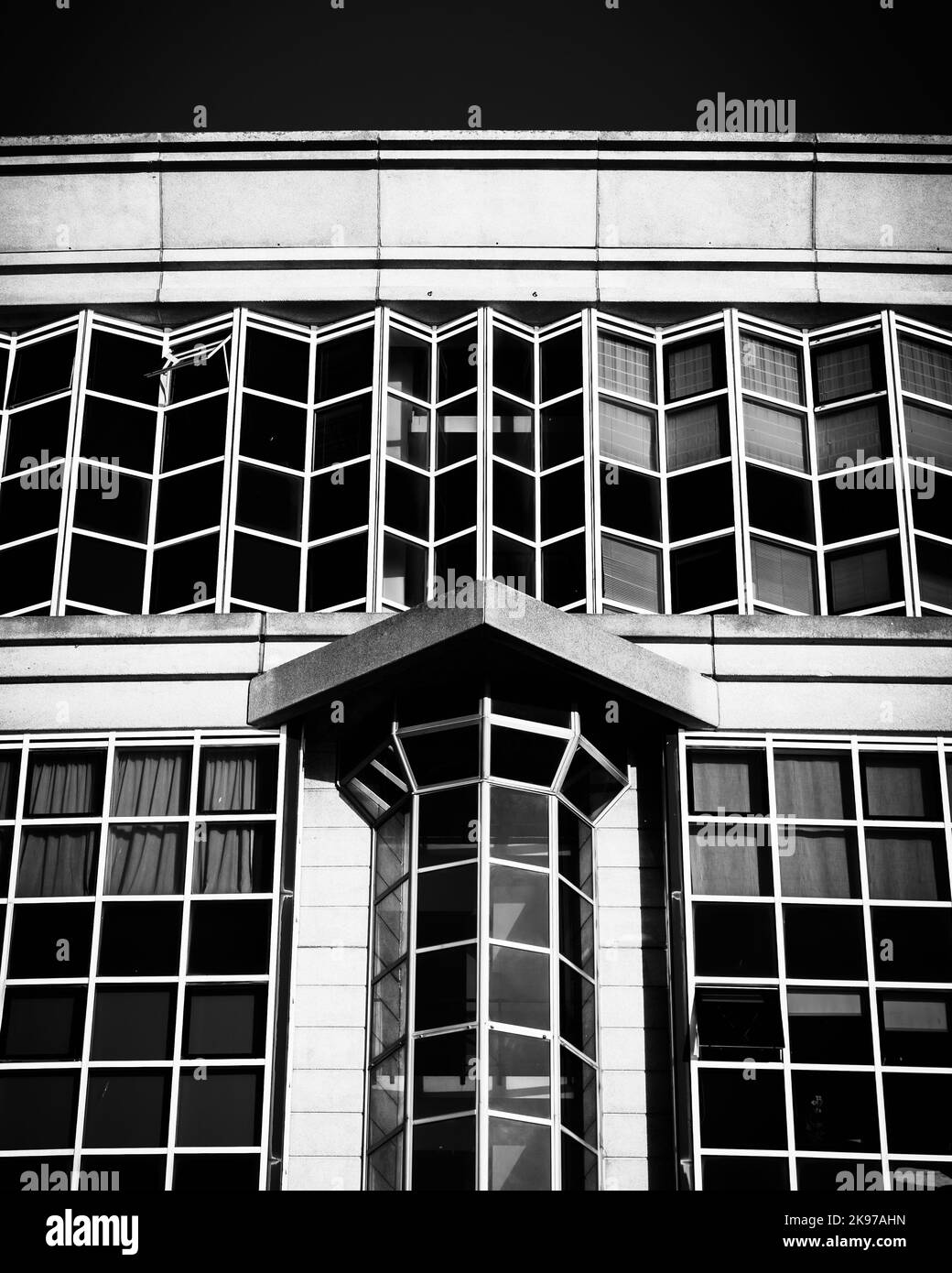 Une photo en niveaux de gris d'un bâtiment moderne avec un mur de verre Banque D'Images