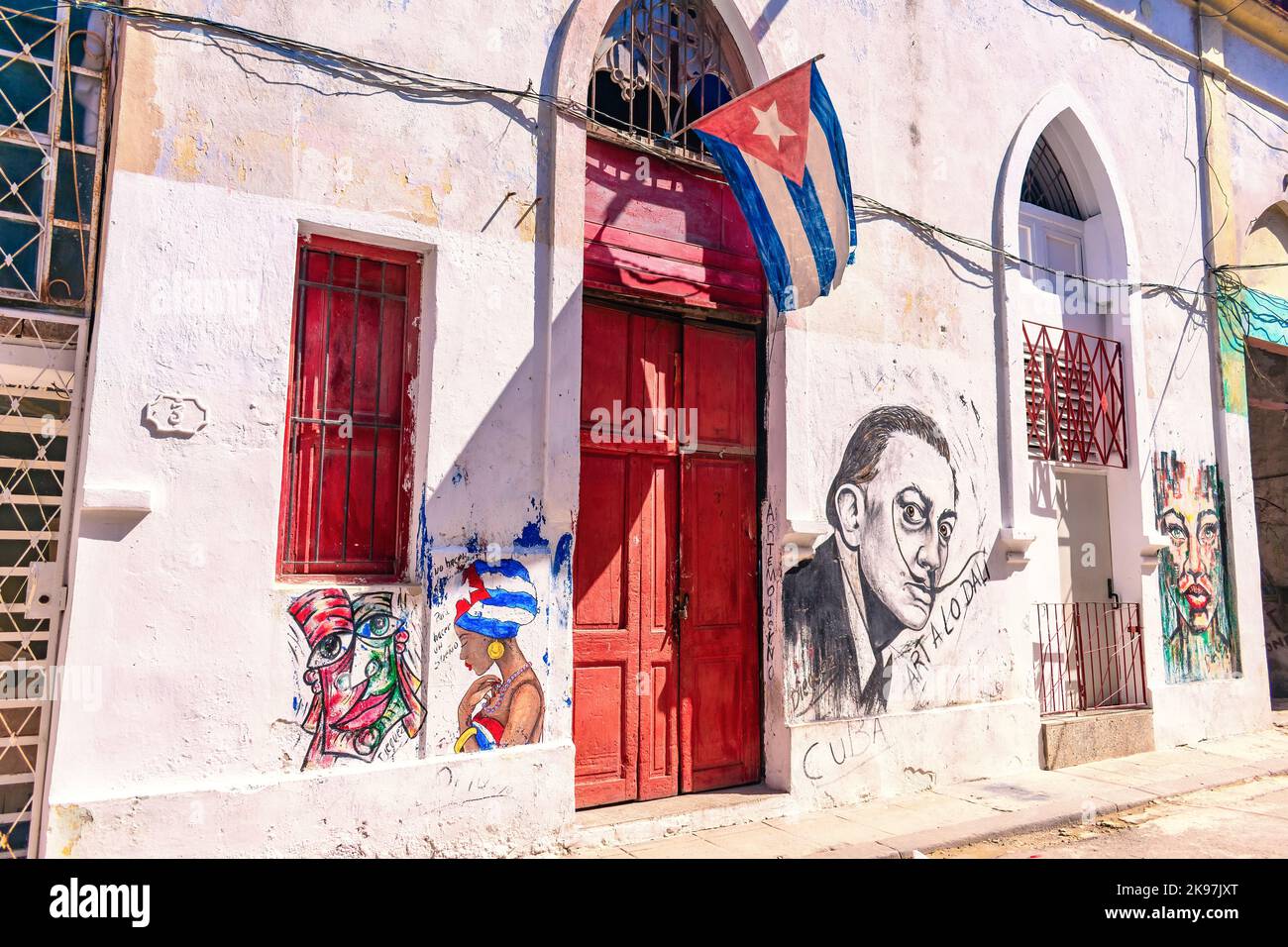 Façade d'un bâtiment aux peintures urbaines et drapeau cubain sur la porte d'entrée Banque D'Images