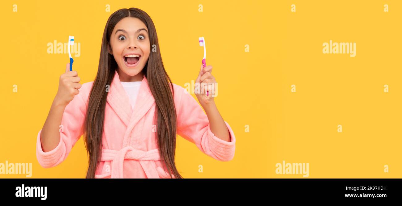 routine du matin. enfant porte une combinaison de nuit douce. enfant dans un vêtement de nuit confortable brosse les dents. Bannière d'enfant fille avec brosse à dents, portrait de studio, en-tête avec Banque D'Images