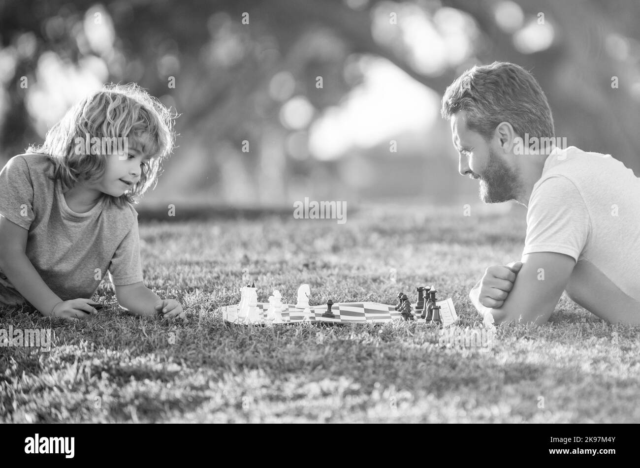 père et fils jouant aux échecs dans le parc du matin. fête des pères. famille heureuse. famille parenthood Banque D'Images