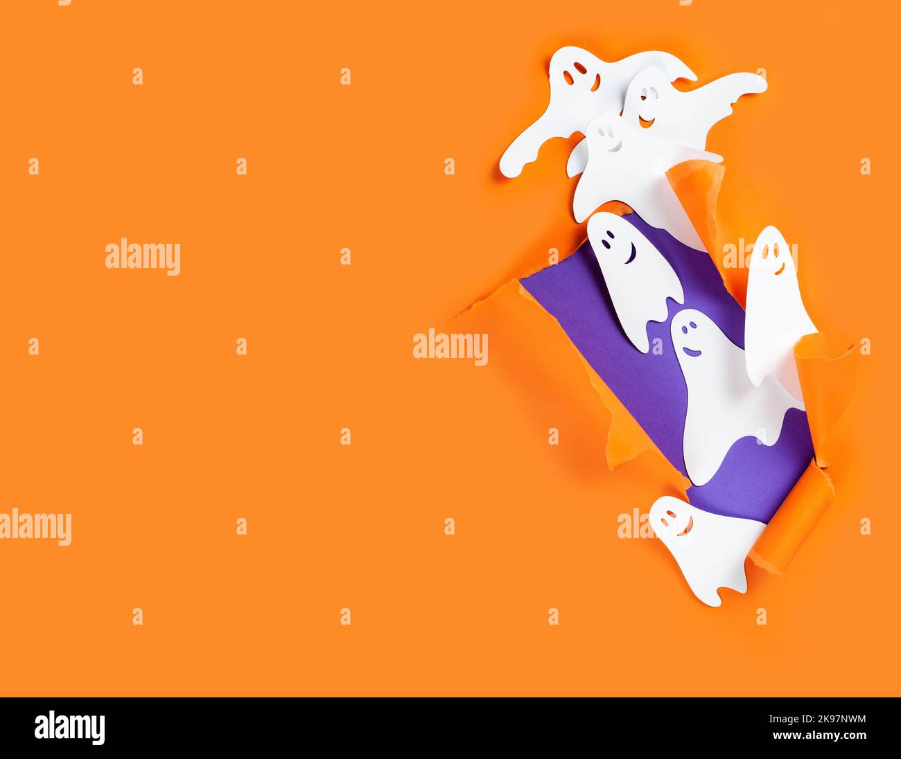 Bannière Halloween avec fantômes papier sur fond orange avec espace de copie. Banque D'Images