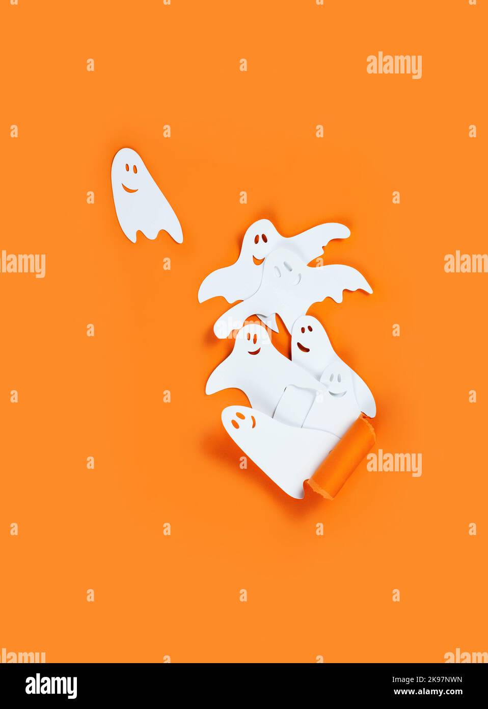 Bannière Halloween avec des fantômes en papier sur fond orange. Banque D'Images