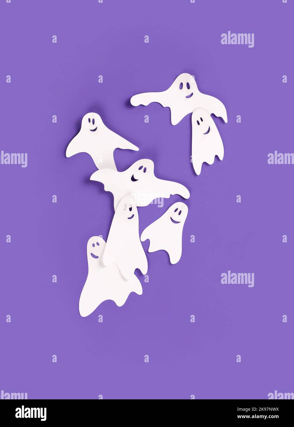 Bannière Halloween avec des fantômes en papier sur fond violet. Banque D'Images