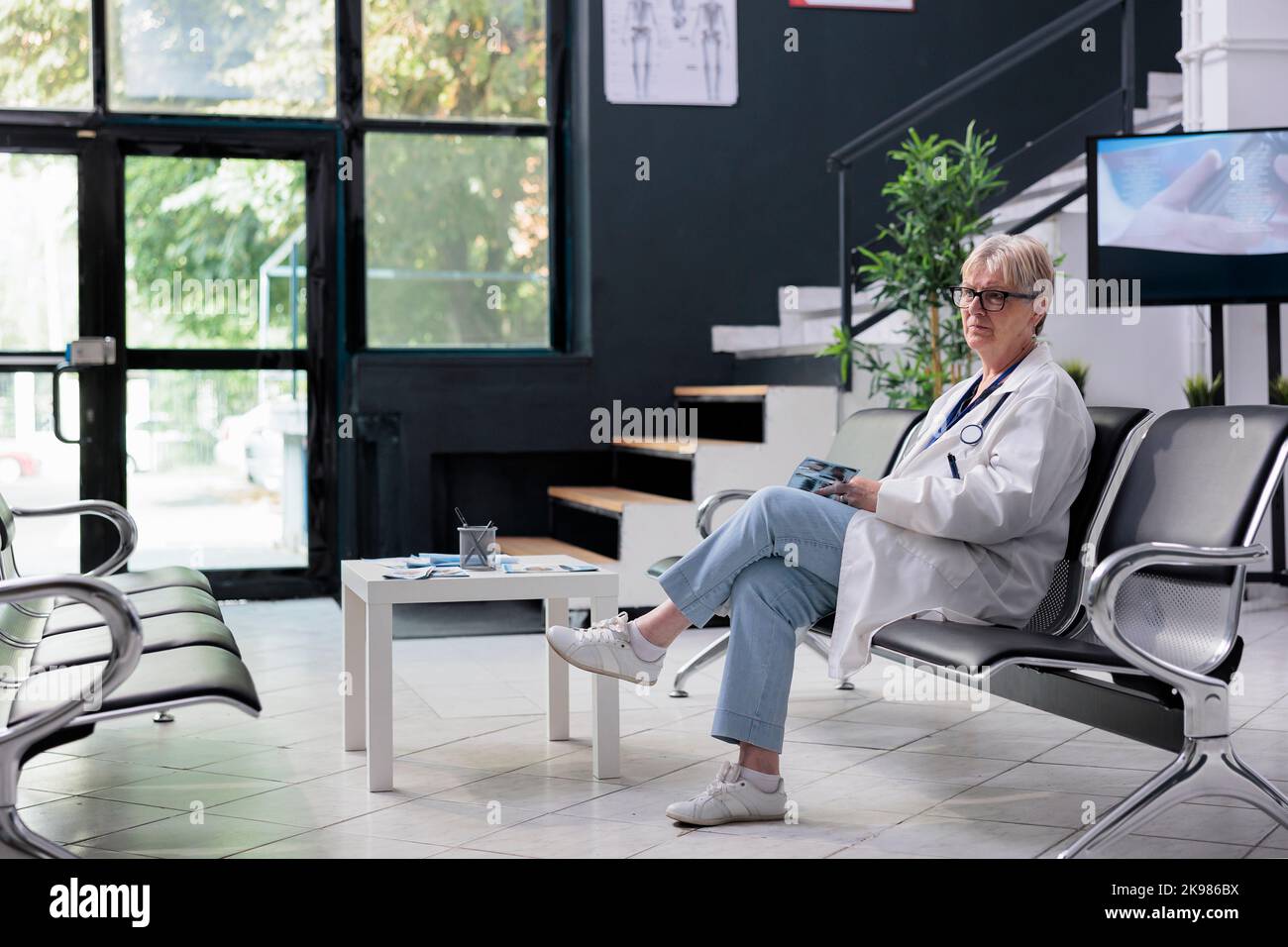 Portrait d'une femme âgée assise dans un hôpital attendant d'assister à un examen médical avec des patients. Médecin senior chargé de l'acquisition d'examen radiographique. Concept de médecine Banque D'Images