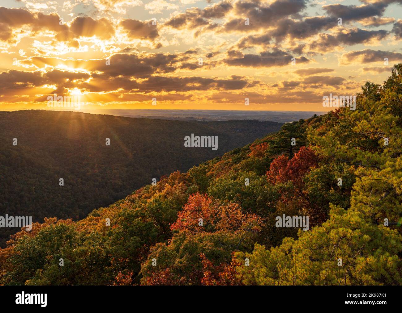 Coucher de soleil derrière les nuages illuminant les couleurs d'automne des arbres dans la forêt nationale de Coopers Rock Banque D'Images