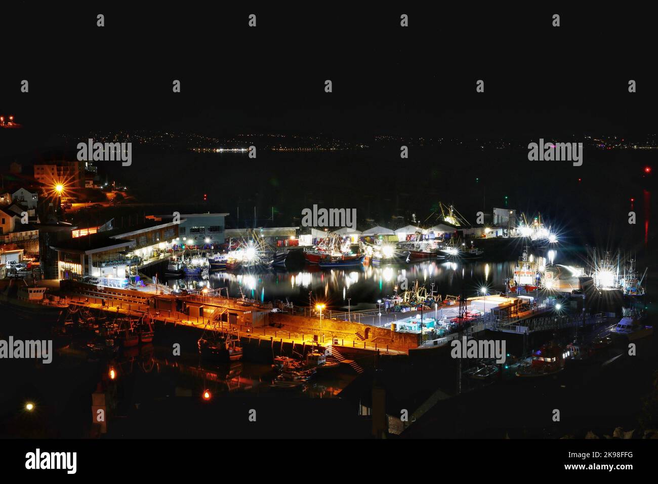 Vue nocturne des chalutiers de pêche amarrés dans le port de travail de Brixham, Devon, Royaume-Uni Banque D'Images