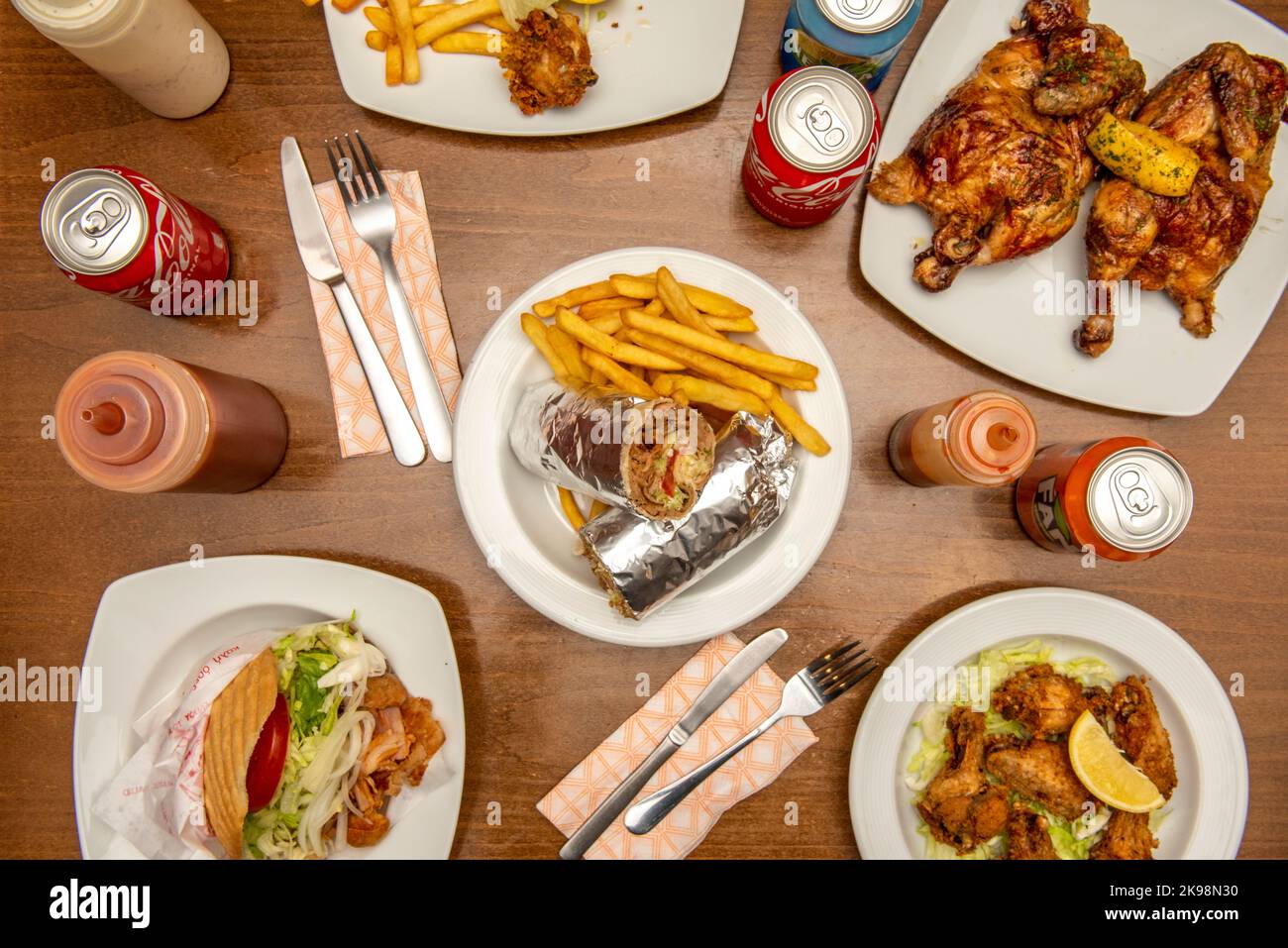 Ensemble de plats typiques de restaurant kebab avec sandwich au blé dur avec viande d'agneau avec salade, viande, laitue et oignon sur une assiette blanche sur une table en bois Banque D'Images
