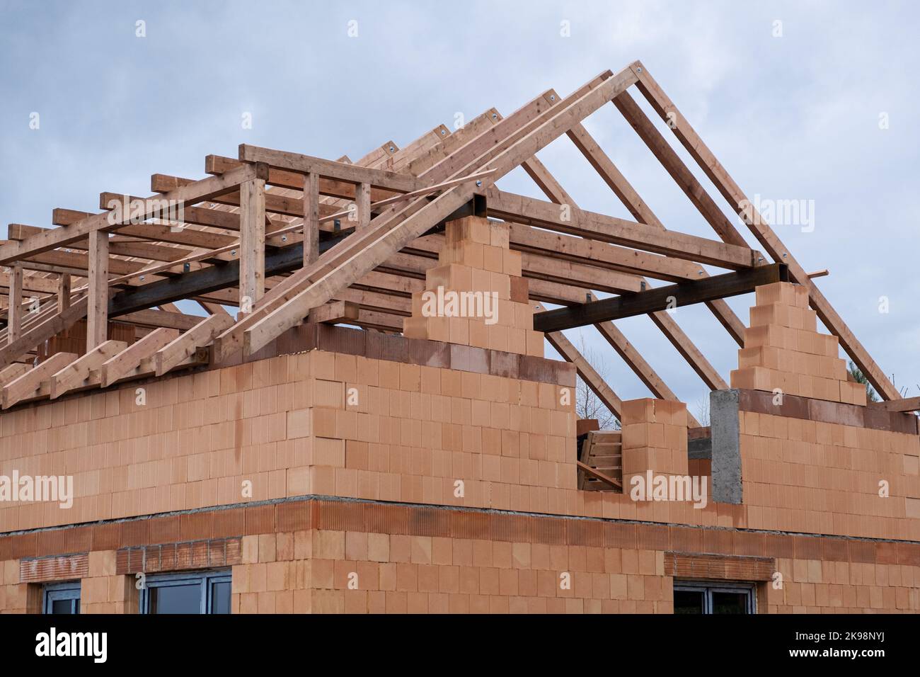 Construction de toit sur un nouveau mur de briques en céramique, le début de la base en bois pour le toit, bois et bois de métal. Travaux de construction , maison de bloc de céramique Banque D'Images