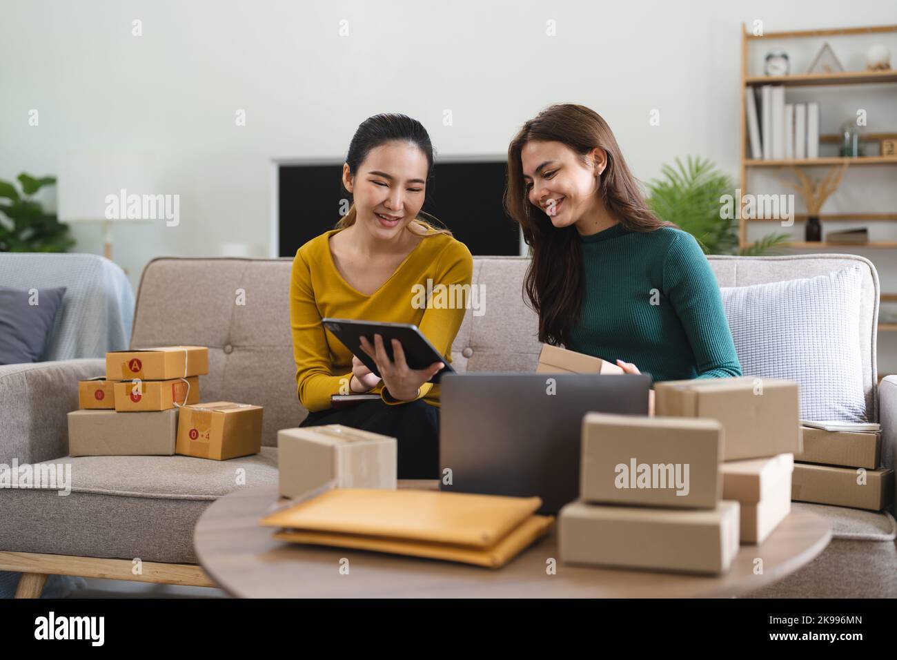 Jeune femme d'affaires travaillant en ligne e-commerce shopping à sa boutique. Jeune femme vendeur prépare la boîte de colis du produit pour la livraison au client. En ligne Banque D'Images