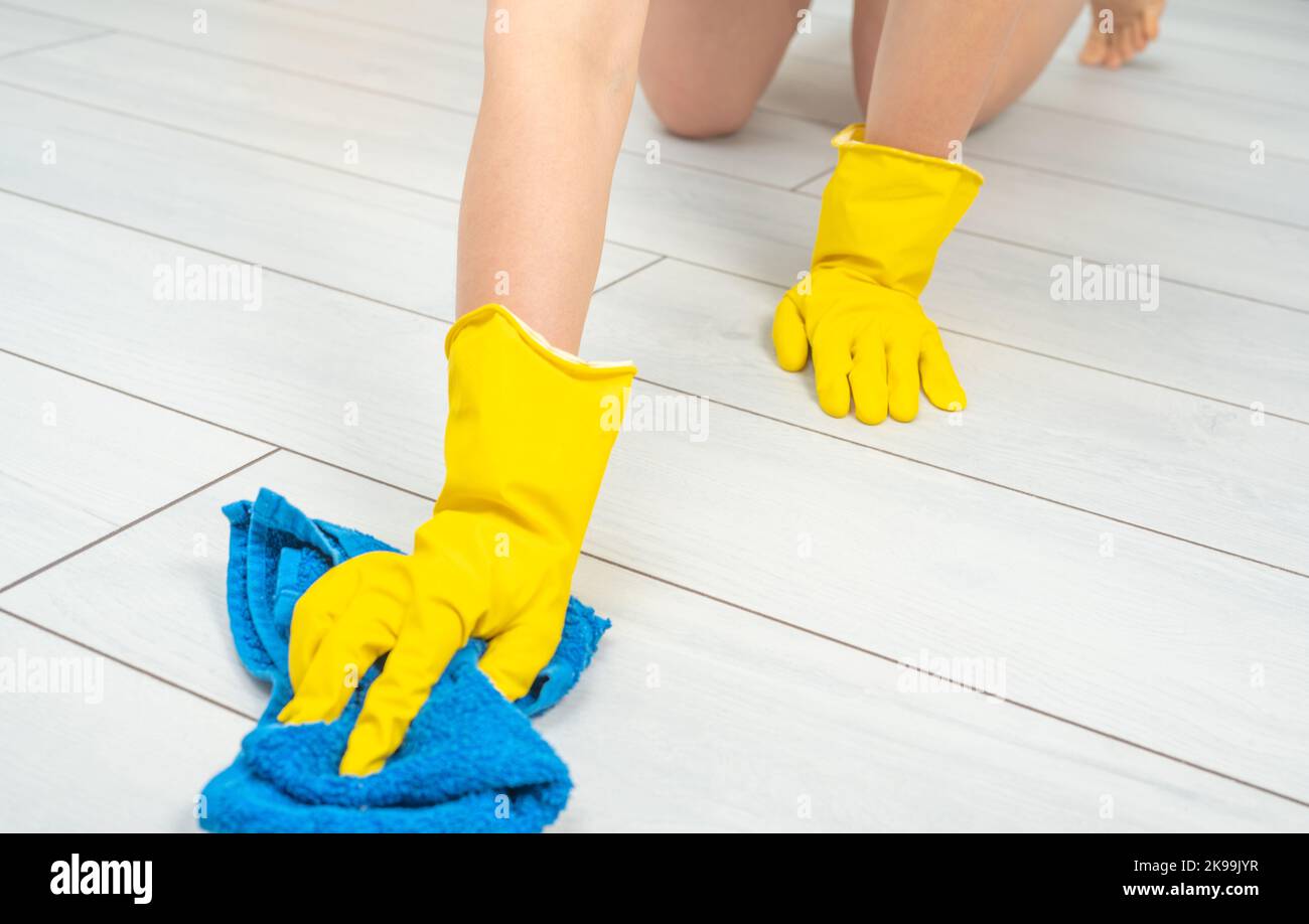 Gros plan de la jeune femme pieds nus qui nettoie le sol stratifié en bois blanc à l'aide d'un chiffon humide en microfibre. Nettoyage de la surface de vente des jeunes Maid, entretien ménager, co Banque D'Images