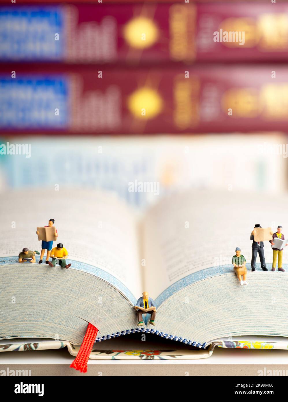 Gros plan de figurines miniatures d'un groupe de personnes lisant des livres et des journaux. Banque D'Images