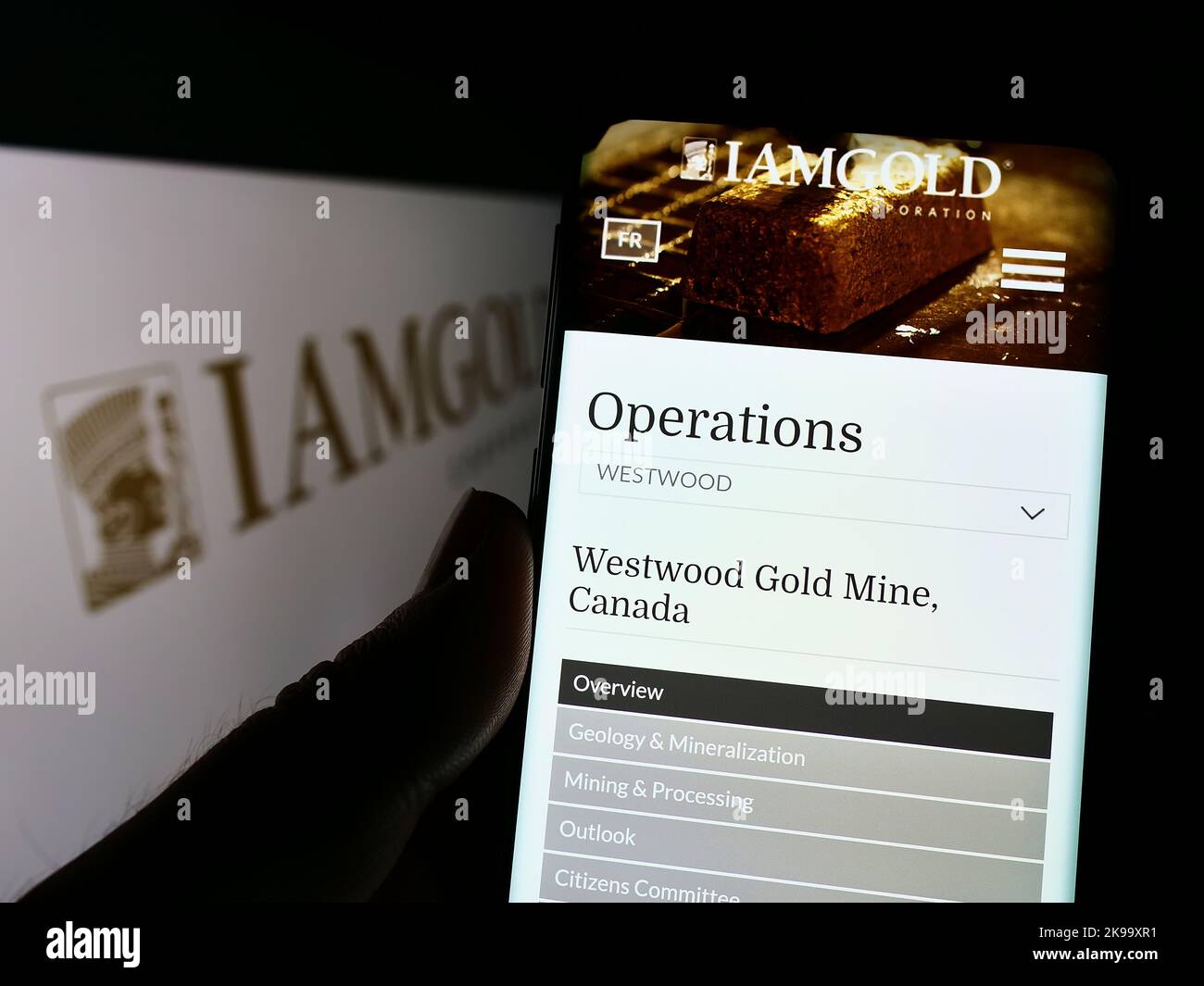 Personne tenant un téléphone cellulaire avec le site Web de la société minière canadienne IAMGOLD Corporation à l'écran devant le logo. Concentrez-vous sur le centre de l'écran du téléphone. Banque D'Images