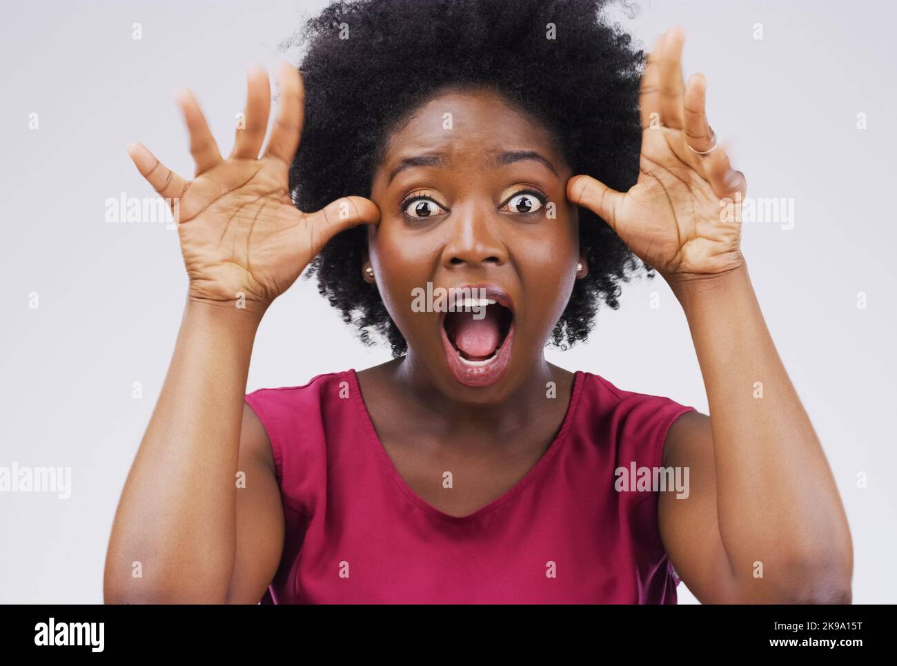Exprimez votre côté amusant. Studio photo d'une jeune femme faisant un visage drôle sur fond gris. Banque D'Images