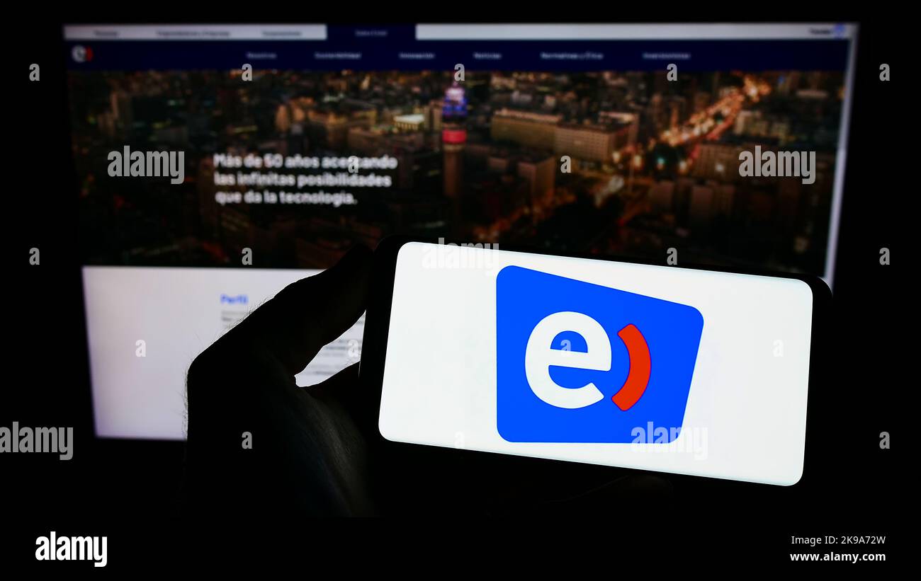 Personne tenant un téléphone portable avec le logo de la société de télécommunications Entel Chile à l'écran en face de la page Web d'affaires. Mise au point sur l'affichage du téléphone. Banque D'Images Personne tenant un téléphone portable avec le logo de la société de télécommunications Entel Chile à l'écran en face de la page Web d'affaires. Mise au point sur l'affichage du téléphone. Banque D'Images