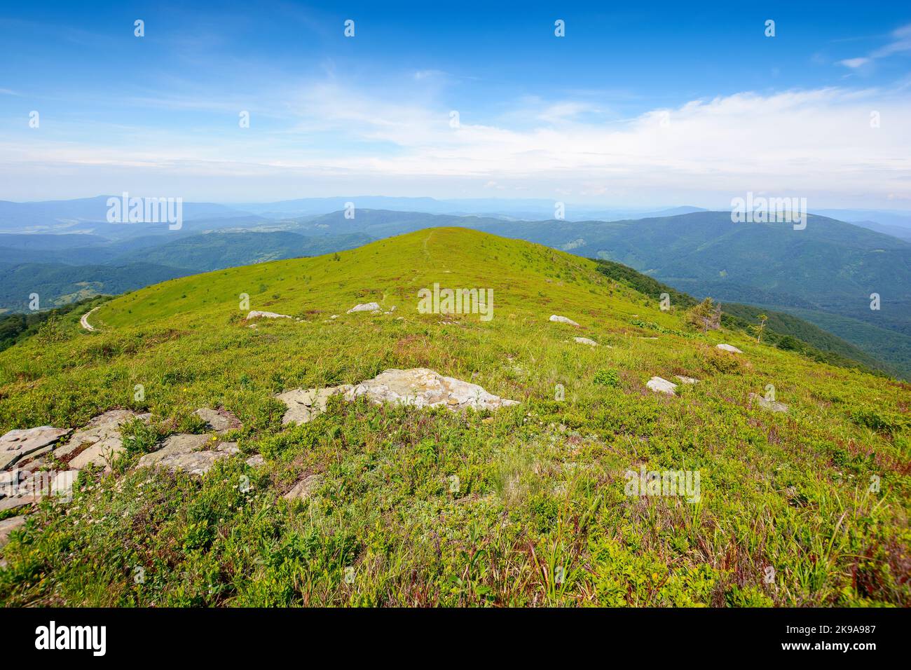 paysage alpin des montagnes carpathes. pierres sur les collines herbeuses. temps ensoleillé avec nuages au-dessus de la crête lointaine Banque D'Images