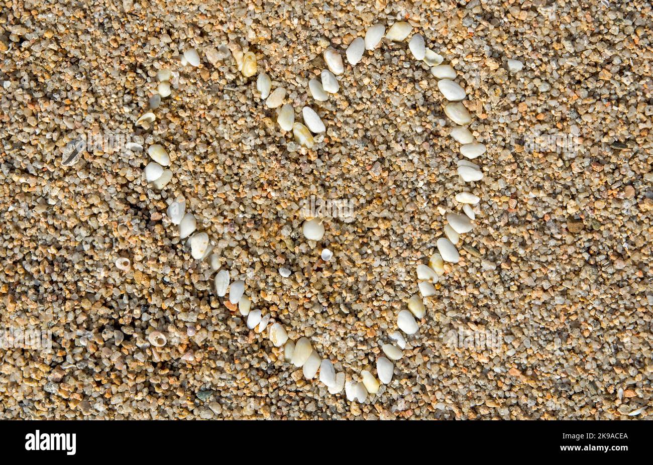 Un cuore, realizzato con delle piccole conchiglie. Spiaggia di Caprera, Sardaigne. Banque D'Images