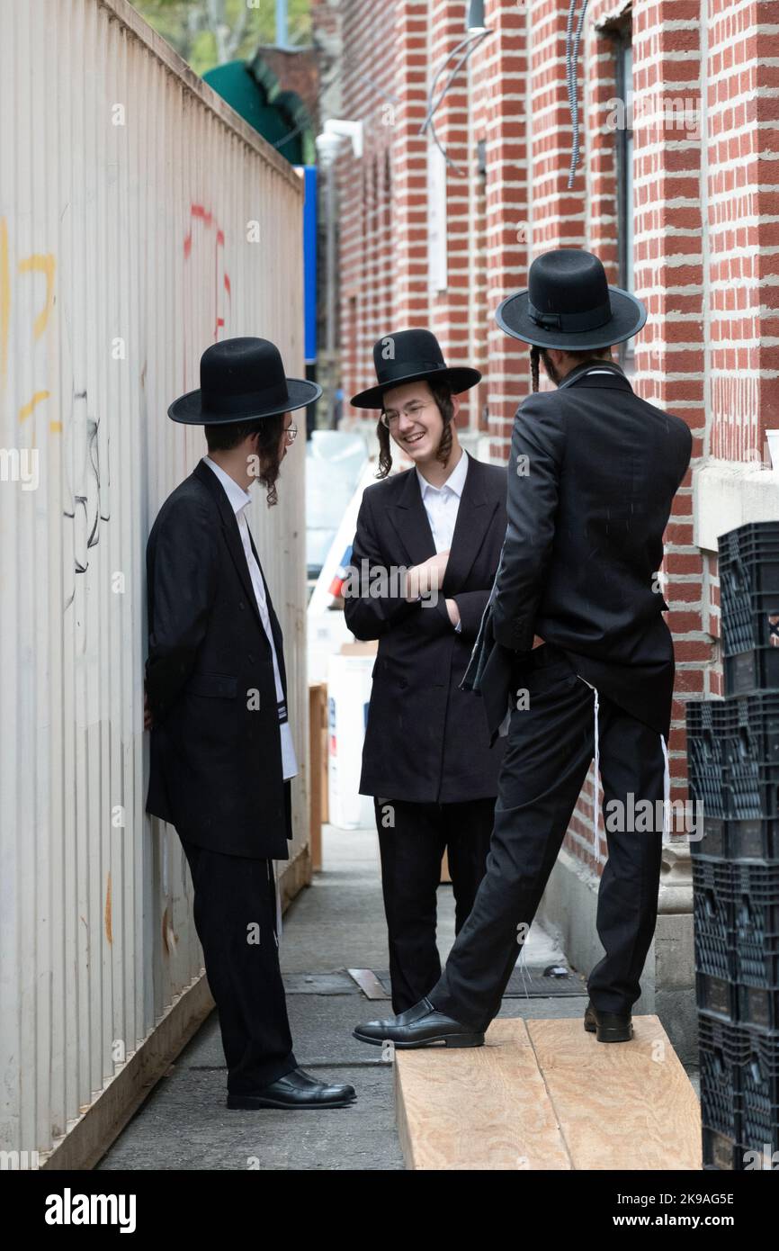 3 hommes juifs orthodoxes socialisent et rient après le matin dans une synagogue Vien à Brooklyn, New York. Banque D'Images