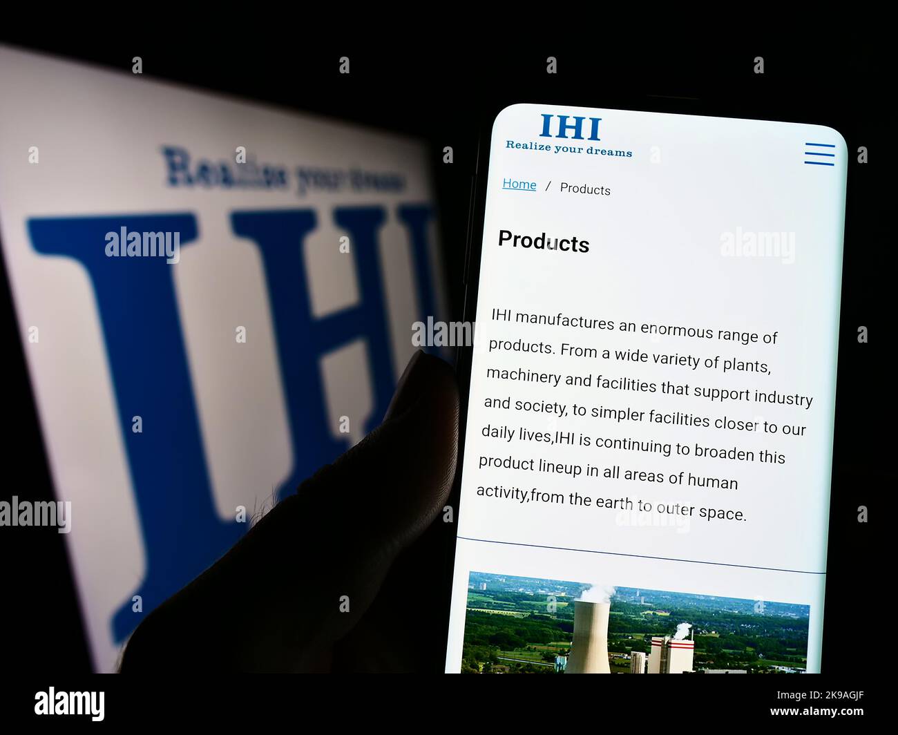 Personne tenant un téléphone portable avec la page Web de la société japonaise d'ingénierie IHI Corporation à l'écran avec logo. Concentrez-vous sur le centre de l'écran du téléphone. Banque D'Images