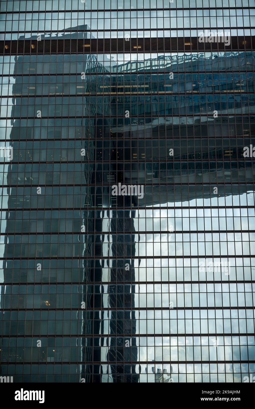 Le design voûté du bâtiment des bureaux du gouvernement central se reflète dans la façade en verre de la tour Admiralty Centre Tower 1, sur l'île de Hong Kong Banque D'Images