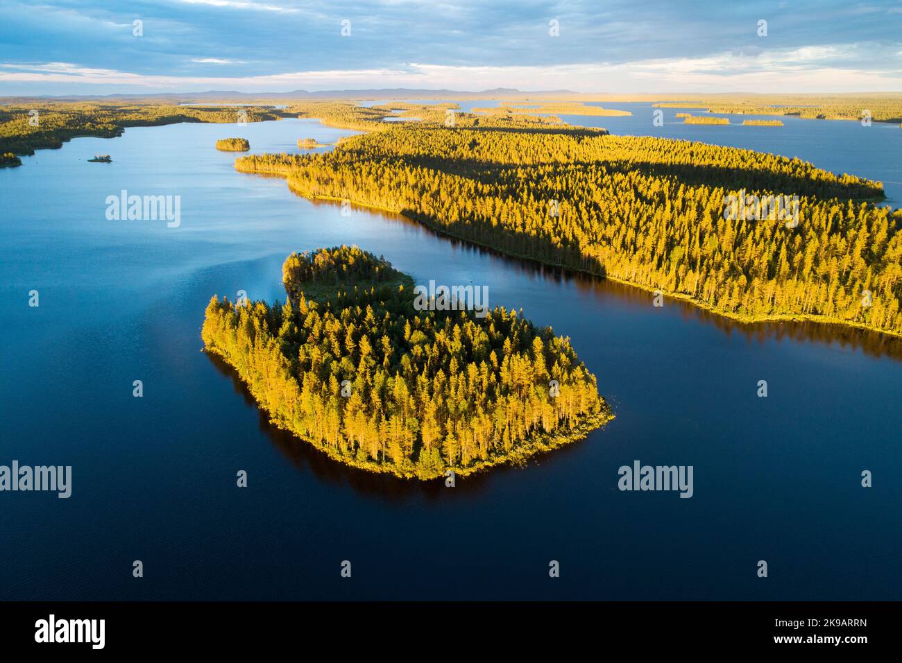 Île boisée pendant un beau coucher de soleil en été dans le nord de la Finlande Banque D'Images