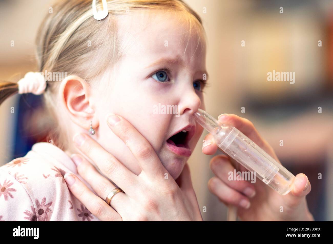 La mère nettoie le nez de bébé. Aspiration nasale reliée au nettoyant à vide Banque D'Images