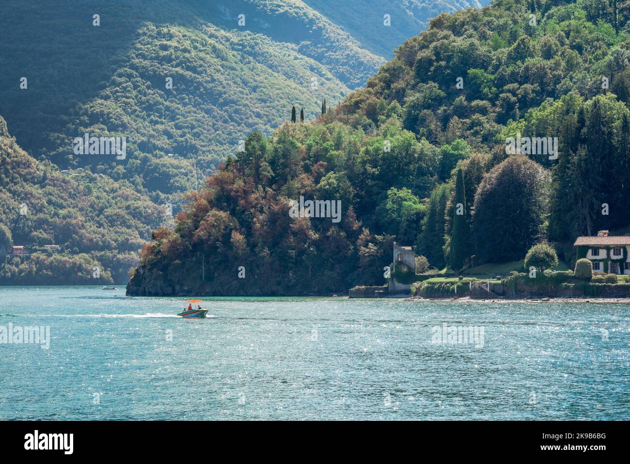 Lac Lenno de Côme, vue en été d'un petit bateau naviguant près de la péninsule de Lavedo sur laquelle se trouve la Villa di Balbianello, lac de Côme, Lenno, Italie Banque D'Images