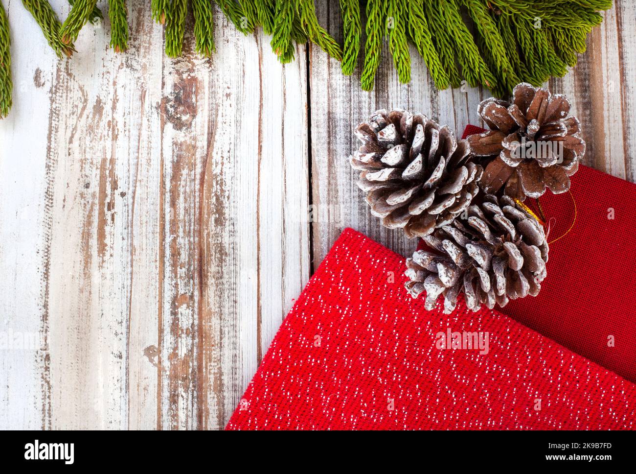 Arrière-plan de Noël rustique avec feuilles de pin et pommes de pin sur une surface en bois blanchi à la chaux avec espace de copie Banque D'Images