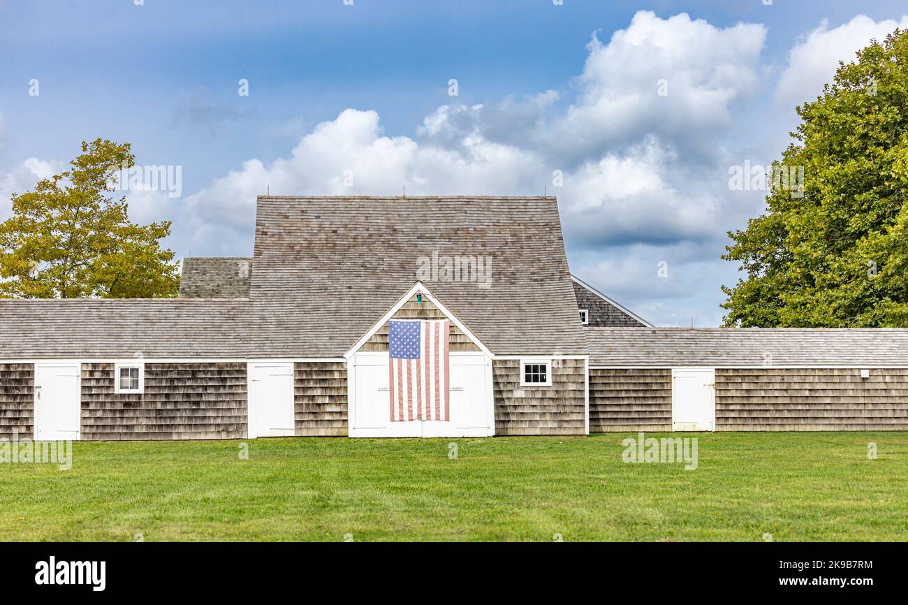 Ancienne grange Wainscott avec un drapeau américain suspendu à l'avant Banque D'Images