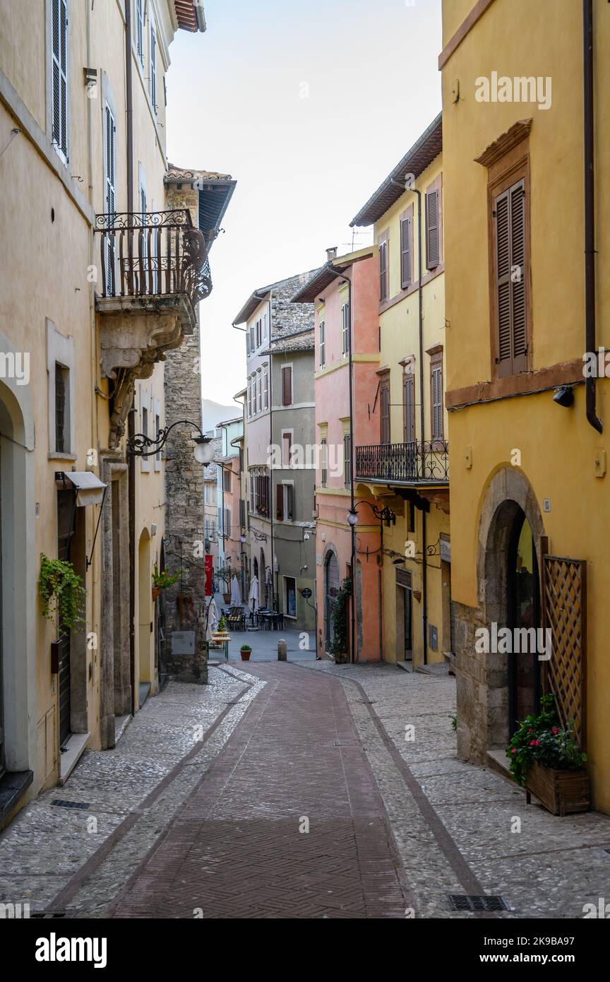 Une scène de rue typique dans la vieille ville de Spoleto avec des maisons traditionnelles en pierre et des ruelles étroites photographiées tôt le matin. Ombrie, Italie. Banque D'Images