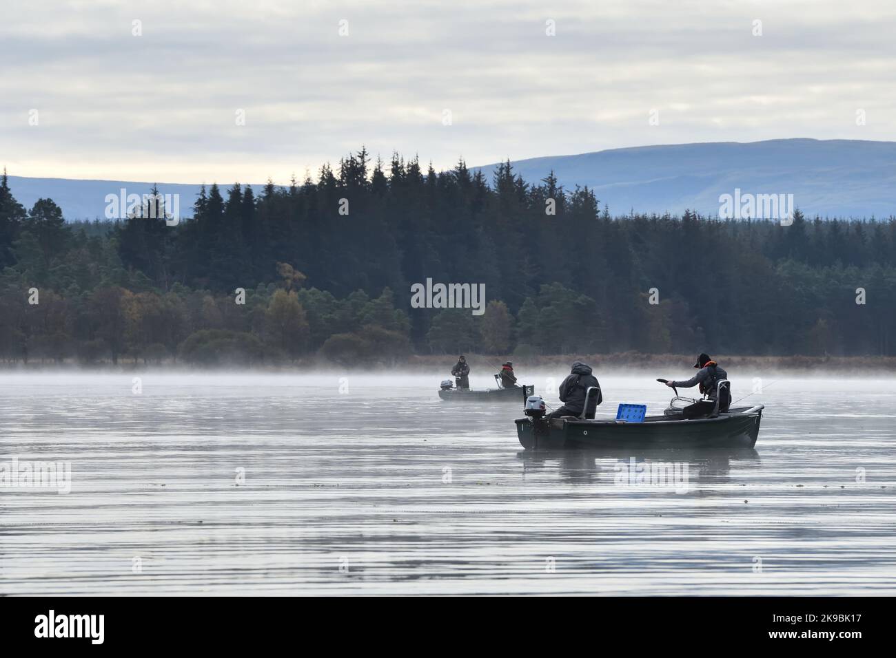 Un homme débarque une truite arc-en-ciel un matin brumeux tout en pêchant à bord d'un bateau sur le lac de Mengeith en Écosse, au Royaume-Uni Banque D'Images Un homme débarque une truite arc-en-ciel un matin brumeux tout en pêchant à bord d'un bateau sur le lac de Mengeith en Écosse, au Royaume-Uni Banque D'Images