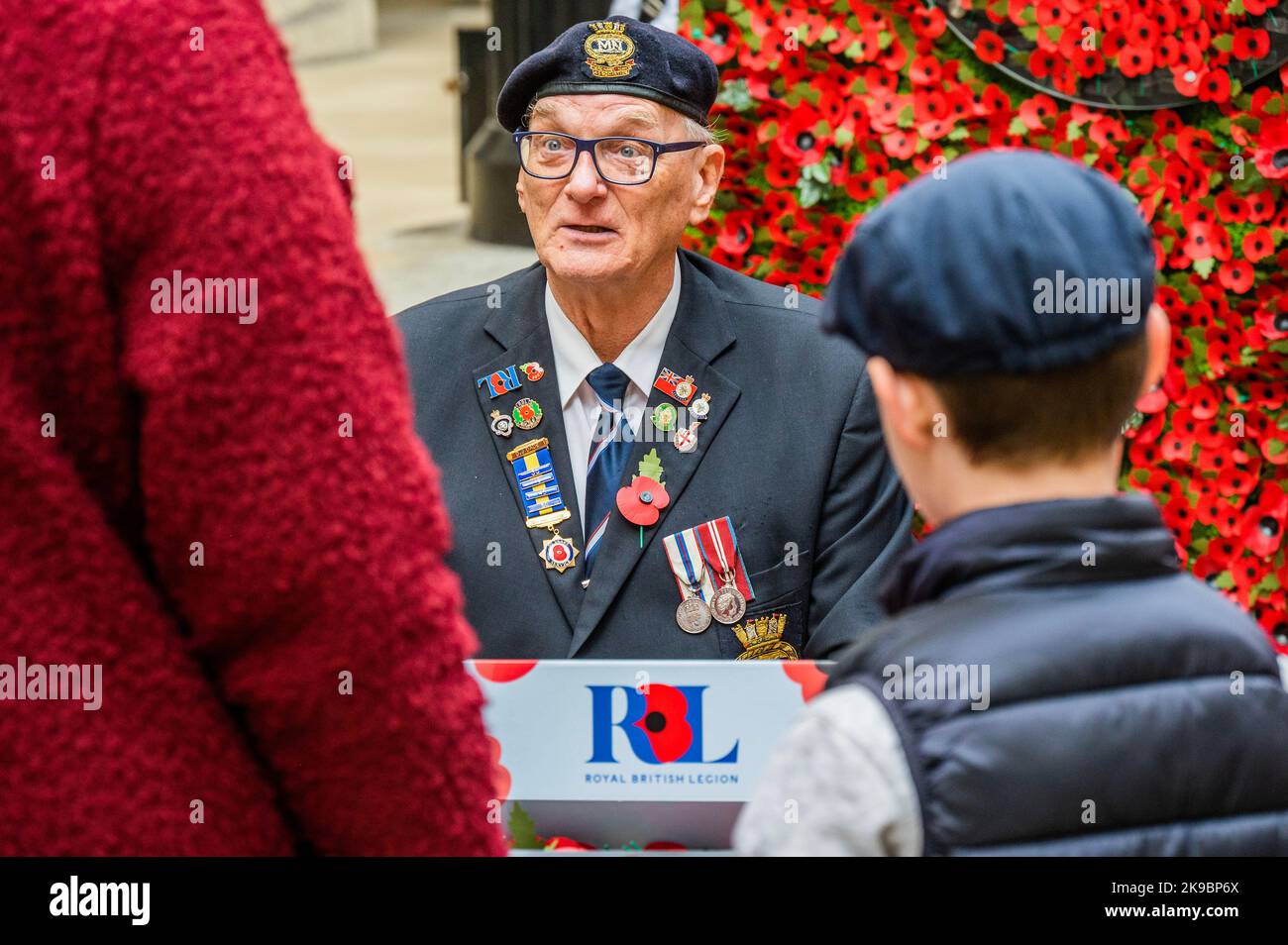 Londres, Royaume-Uni. 27 octobre 2022. David Dade, un vétéran de la marine marchande avec 50 ans de service au RBL, aide - le Poppy Appeal 2022 de la Royal British Legion lance avec un mur de coquelicots de 6 mètres de large présentant des histoires d'anciens combattants, des bénéficiaires RBL (beaucoup ayant reçu un soutien de sauvetage) et leurs familles - les gens derrière le coquelicot. Les membres du public ont été invités à retirer un coquelicot de papier du mur pour découvrir les histoires. L'organisme de bienfaisance exhorte les gens à porter un coquelicot cette année pour montrer qu'ils s'en soucient et que le service et le sacrifice du personnel servant, des anciens combattants et de leurs familles sont sans compromis Banque D'Images