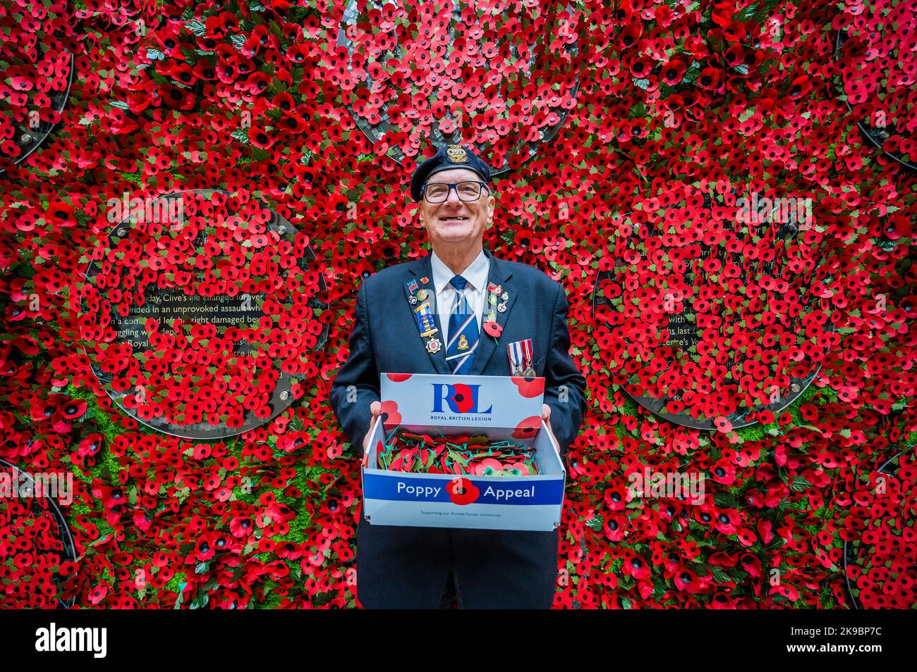 Londres, Royaume-Uni. 27 octobre 2022. David Dade, un vétéran de la marine marchande avec 50 ans de service au RBL, aide - le Poppy Appeal 2022 de la Royal British Legion lance avec un mur de coquelicots de 6 mètres de large présentant des histoires d'anciens combattants, des bénéficiaires RBL (beaucoup ayant reçu un soutien de sauvetage) et leurs familles - les gens derrière le coquelicot. Les membres du public ont été invités à retirer un coquelicot de papier du mur pour découvrir les histoires. L'organisme de bienfaisance exhorte les gens à porter un coquelicot cette année pour montrer qu'ils s'en soucient et que le service et le sacrifice du personnel servant, des anciens combattants et de leurs familles sont sans compromis Banque D'Images