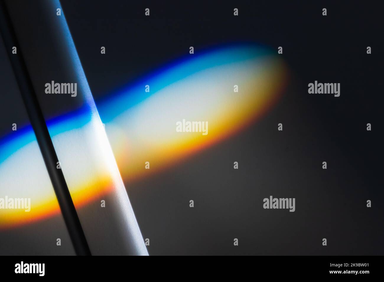Sunbeam avec des couleurs de spectre se pose sur la paroi blanche, effet de réfraction. Photo d'arrière-plan abstraite Banque D'Images