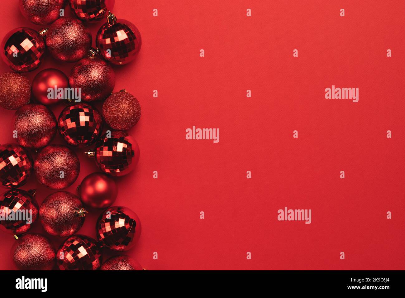 Carte de Noël avec boules rouges scintillantes sur fond rouge et espace pour les copies Banque D'Images