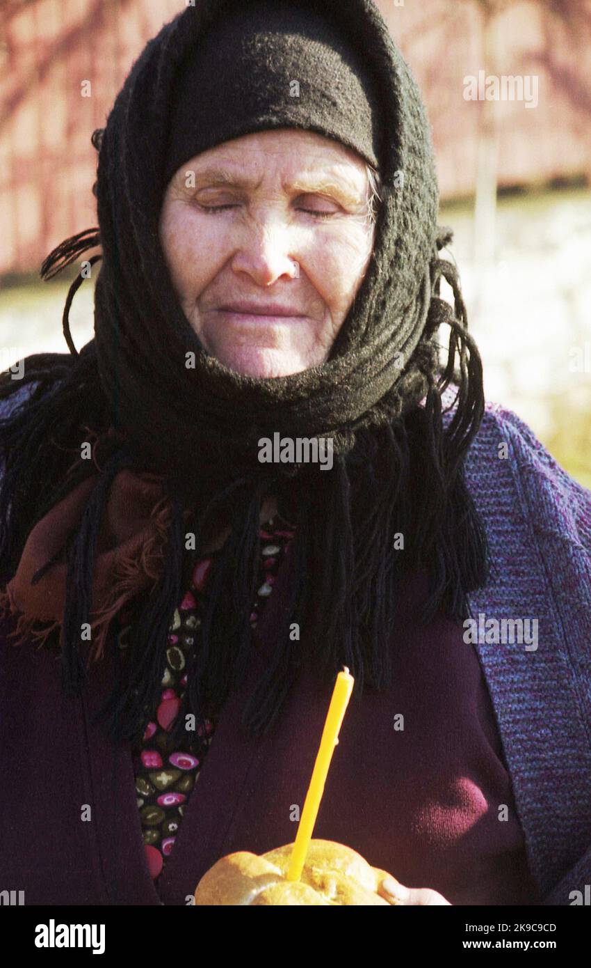 Comté de Gorj, Roumanie, environ 2000. Femme âgée avec du pain et une bougie- alms donnés pour l'âme d'un mort. Coutume religieuse en Roumanie. Banque D'Images