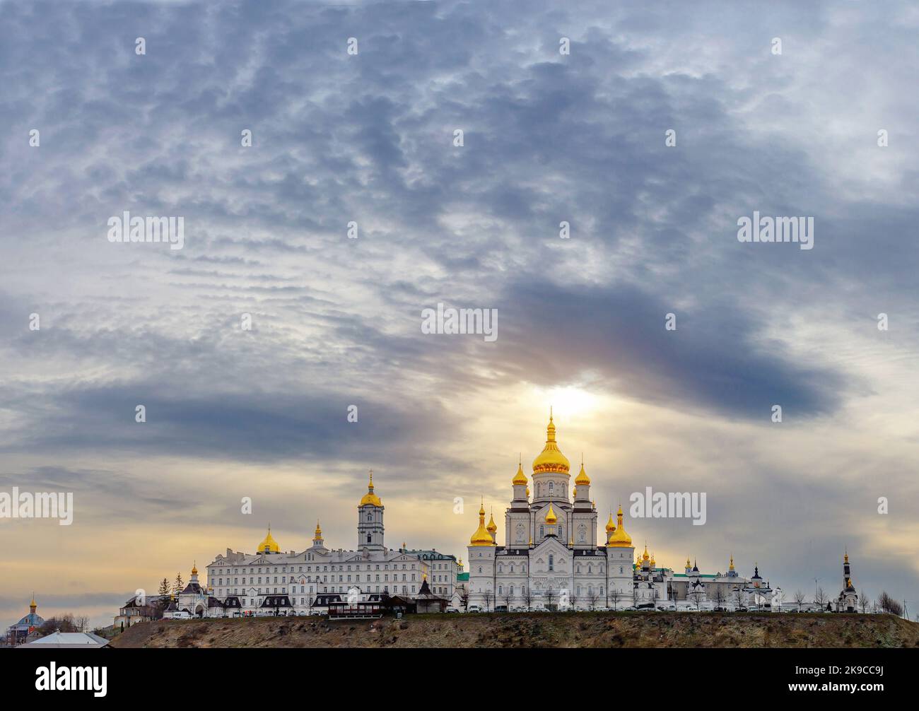 Vue magique de la Sainte Dormition Pochayiv Lavra en Ukraine. Vue panoramique. Lumière du soleil sur le monastère. Les nuages noirs s'accumulent. Banque D'Images