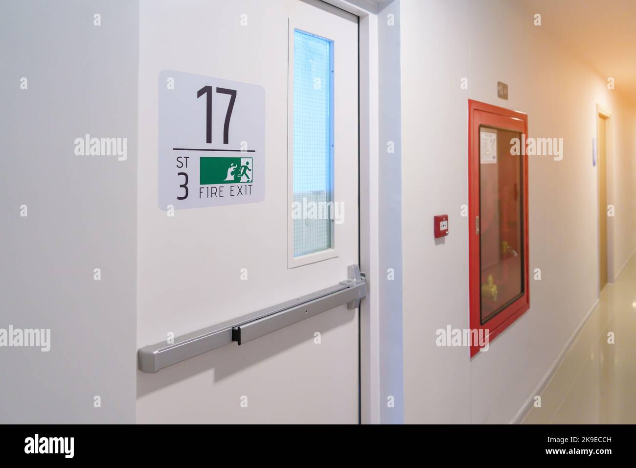 Système d'extincteur sur le mur avec panneau de porte de sortie de secours pour les urgences. Un incendie d'escalier pour s'échapper dans un bâtiment ou un appartement Banque D'Images