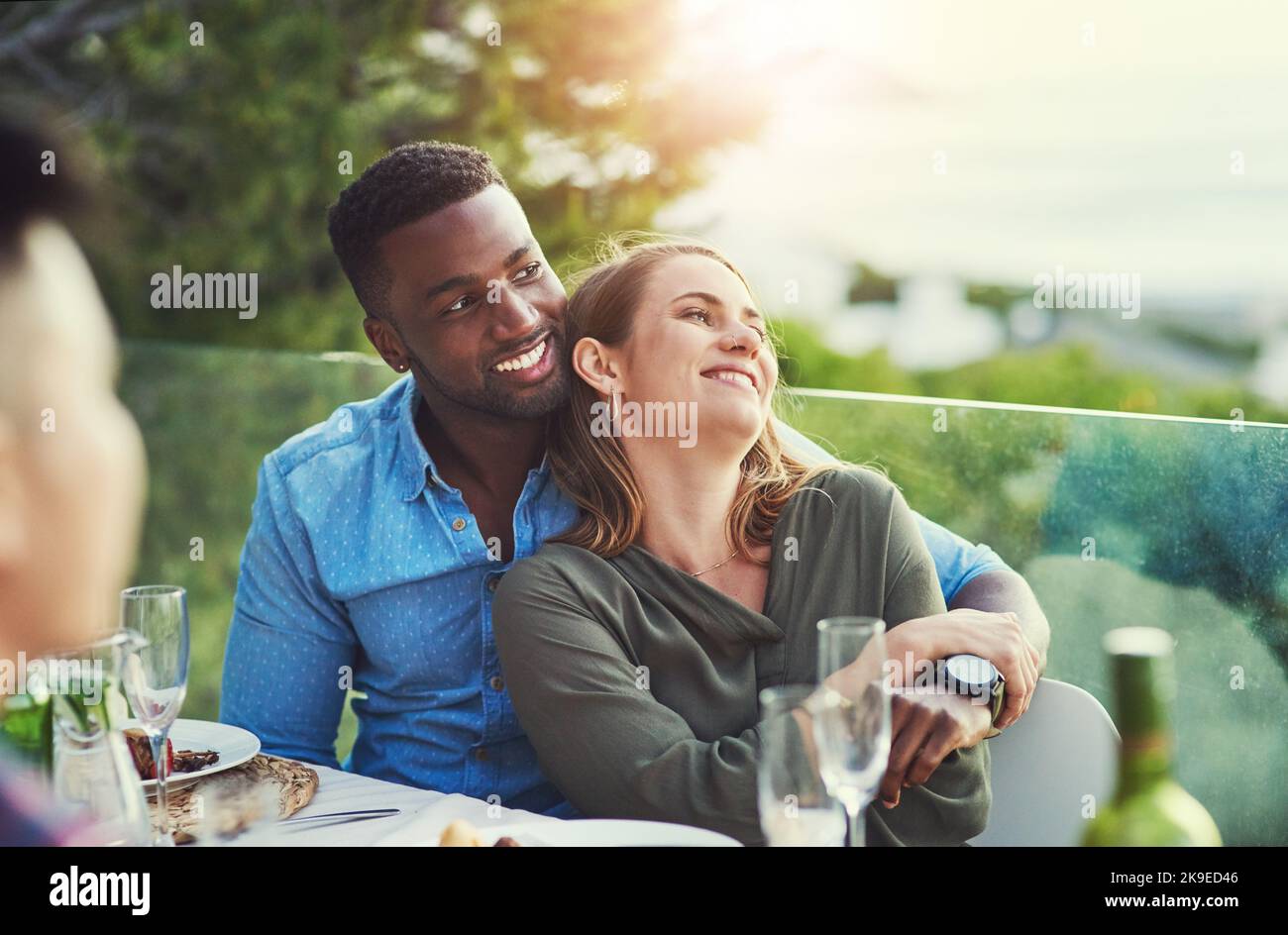Tout se sent mieux avec vous à mes côtés. Un jeune couple affectueux s'amusant autour d'une table de dîner avec des amis à l'extérieur Banque D'Images