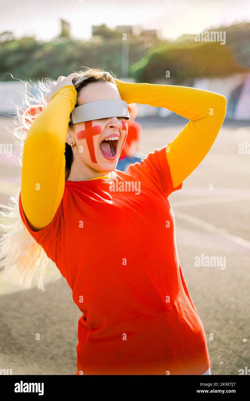Une femme Astonish dans des lunettes VR hurle tout en regardant un match de football Banque D'Images