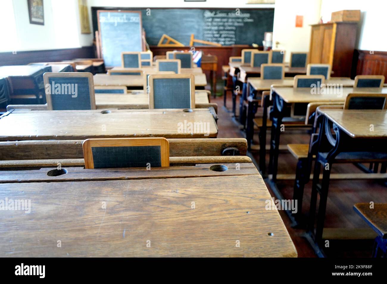 Ancienne salle de classe historique avec bureaux et tableaux en bois Banque D'Images