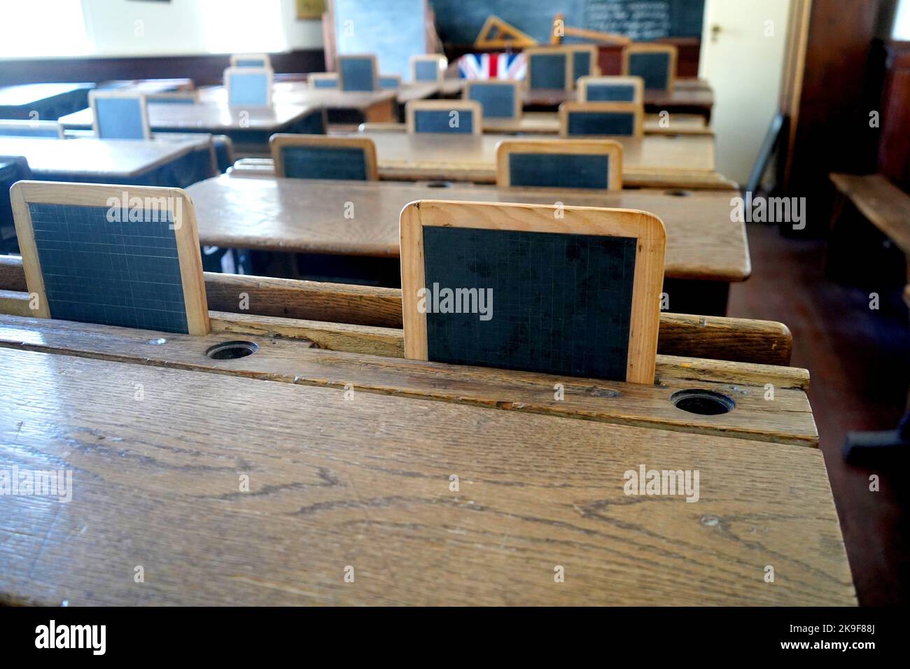 Ancienne salle de classe historique avec bureaux et tableaux en bois Banque D'Images