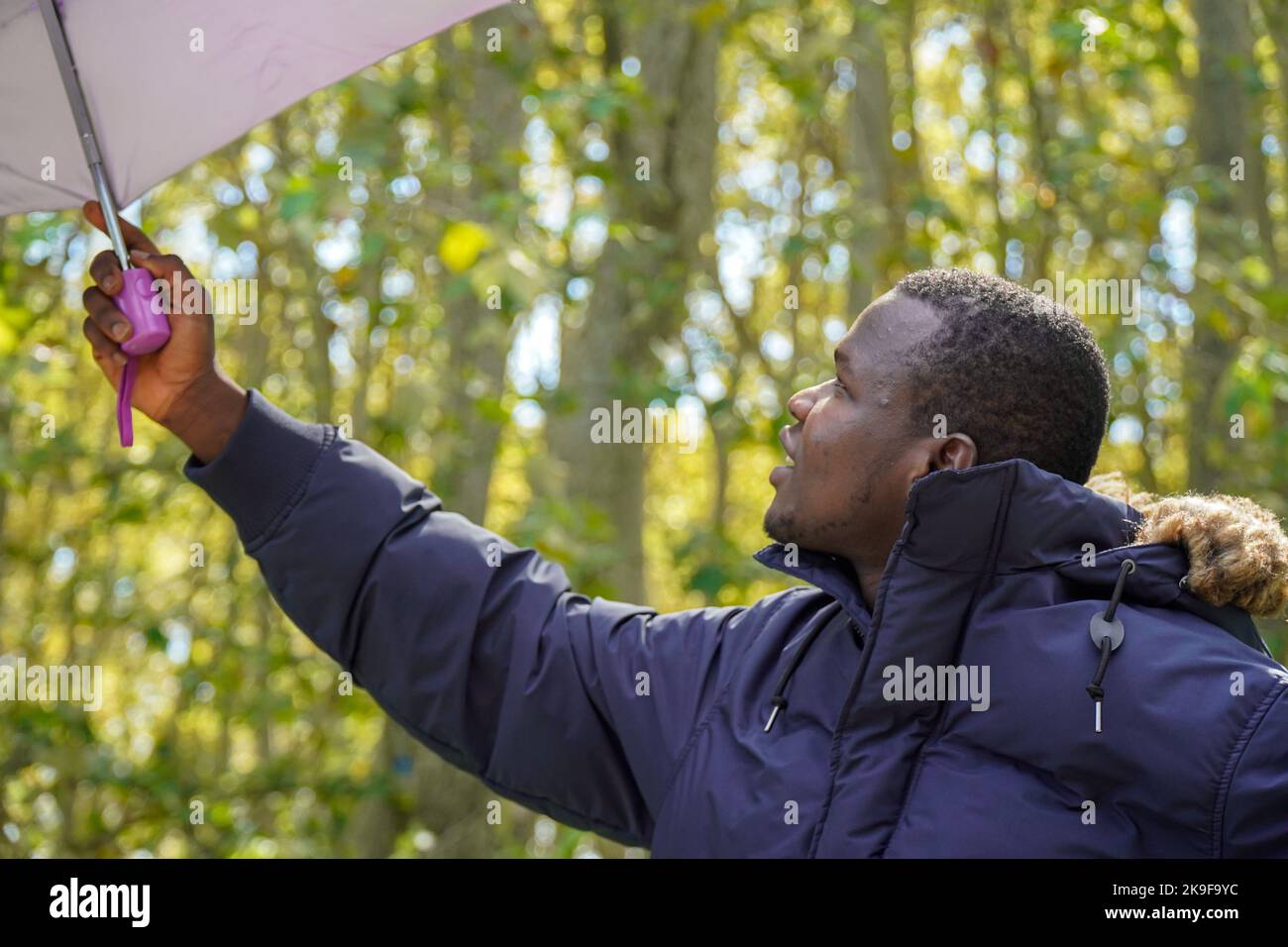portrait d'un jeune africain avec un parapluie dans la nature. mode hiver Banque D'Images