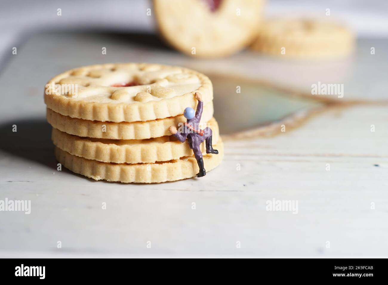 Miniature d'hommes et de biscuit montagne, une série de photographies utilisant des personnes miniatures, des biscuits à la confiture et des cailloux montrant un monde miniature d'images. Banque D'Images