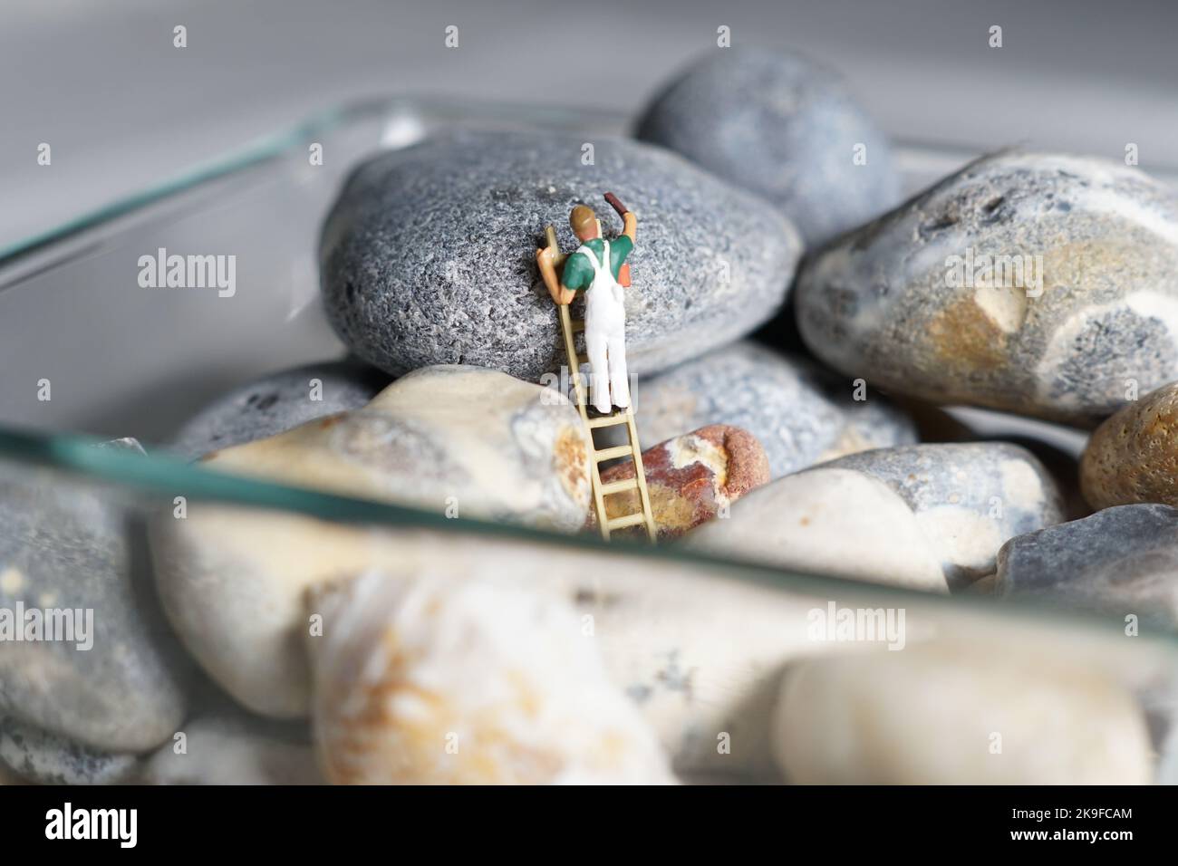 Miniature d'hommes et de biscuit montagne, une série de photographies utilisant des personnes miniatures, des biscuits à la confiture et des cailloux montrant un monde miniature d'images. Banque D'Images