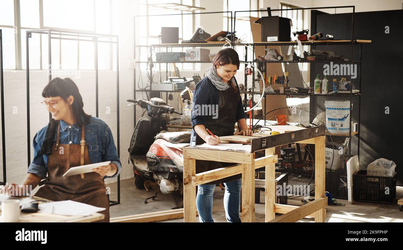 Travailler avec le bois. Deux jeunes artisans créatifs attrayants travaillant dans leur atelier. Banque D'Images