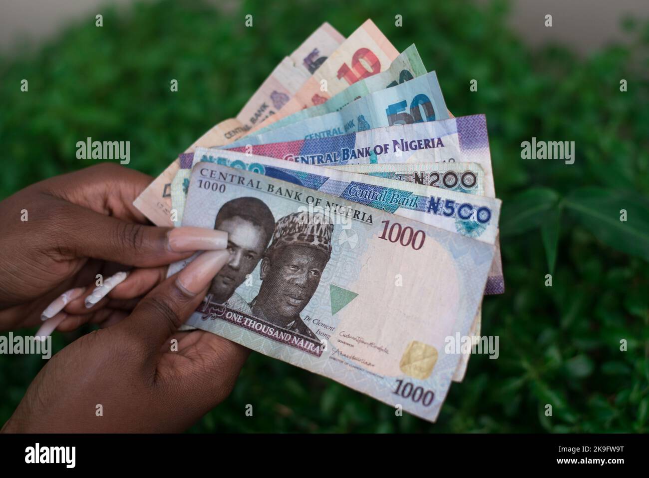 Une personne détenant de l'argent : la Banque du Nigeria prévoit de redessiner le billet de Naira. Présenter une variété de billets nigérians. Banque D'Images