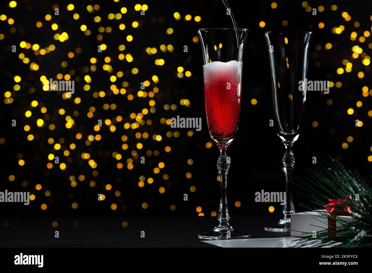 Le début d'une fête de la Saint-Sylvestre ou de Noël. Verser du champagne dans un verre sans personne. Le processus de versement du champagne. Banque D'Images