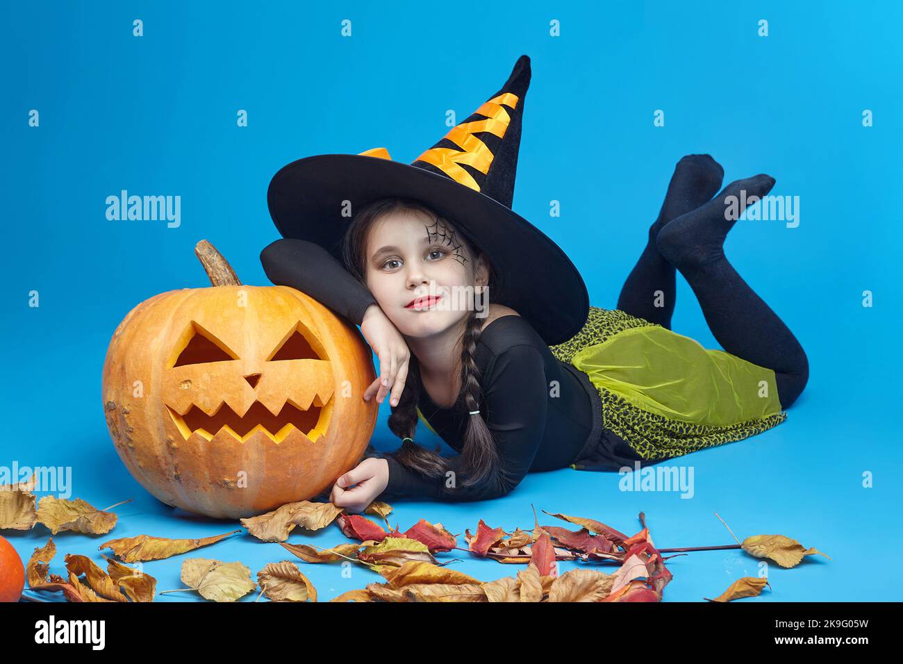 Portrait d'une charmante petite fille dans un costume de sorcière, les lampes de Jack se tiennent autour. Le concept de vacances d'heluin. Banque D'Images